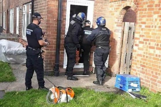 Police raiding a property.