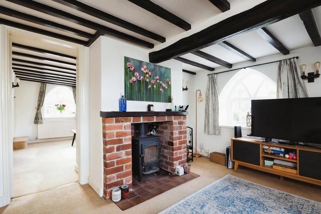 The feature fireplace, with log-burner, is a focal point of the living room, adding warmth. The space flows seamlessly into the dining room to the left.