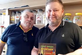 Keith Cutts (left) presents a copy of his new book to Andrew Denham, manager of The Sweet Cafe. Photo: Submitted