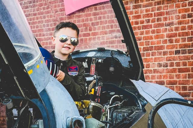Youngster Maverick Gallagher checks out the replica fighter jet cockpit