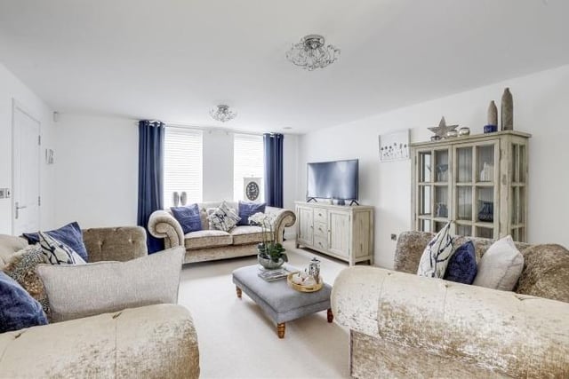 The first reception room to look at is this lovely, generously-sized living room, which has a carpeted floor and two uPVC double-glazed windows facing the front of the house.