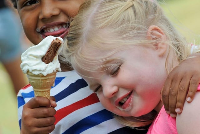 Cousins, Tiffany Jarvis, 2, and 3-year-old Joshua Bernard share a cuddle whilst keeping their cool with ice creams at a fun day on Titchfield Park