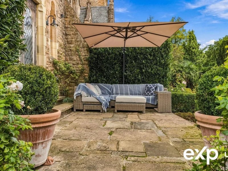 A paved patio seating area stretches across the rear and extends the living space