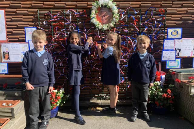 Pupils Tommy, Mia, Primrose and Zac tying ribbons on to the mural at National Primary School in Hucknall. Photo: Lou Brimble