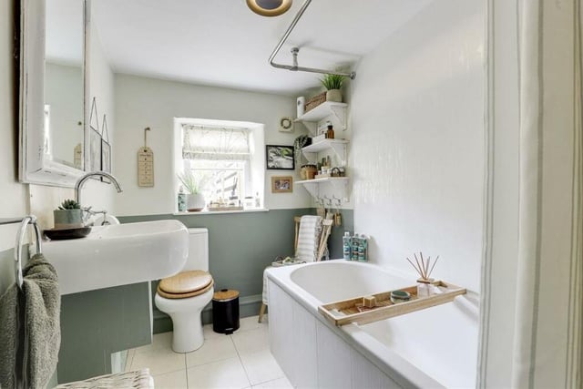 The tastefully appointed, L-shaped bathroom can be found on the ground floor of the £270,000 cottage. It consists of a tiled bath with overhead shower fixture, wall-mounted wash basin, low-level, dual-flush WC and flagstone tiled flooring.