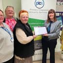 Hucknall resident and carer Marilyn Clifton presents the award to Karen Frankland, managing director of PICS. Photo: Submitted