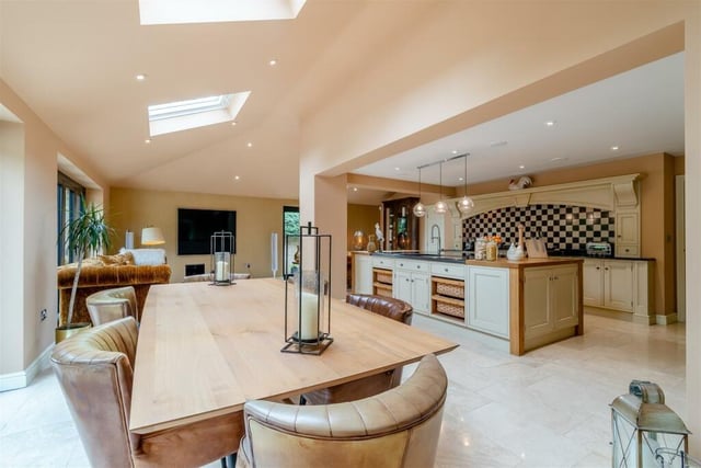 As part of the open-plan kitchen is this dining area, which has a tiled floor and underfloor heating. Other features of the kitchen are a walk-in pantry cupboard, with shelves, and an integrated, full-height fridge with separate full-height freezer.