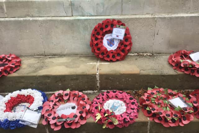 Poppy wreaths laid at the foot of the memorial during the ceremony
