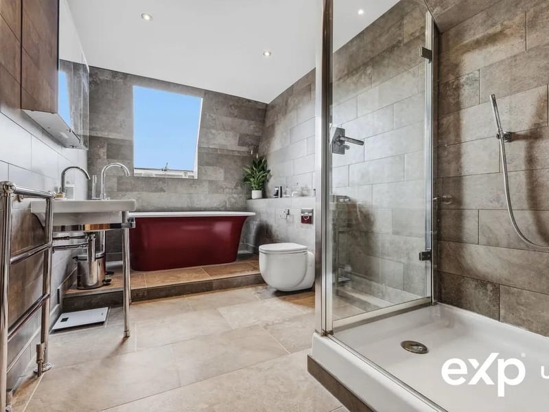 The indulgent bathroom is fitted with a four-piece suite including a freestanding bath and stunning views over the lake
