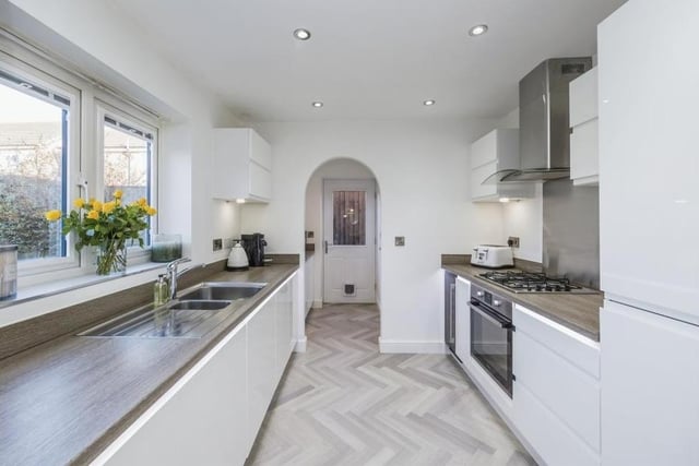 Integrated appliances in the dining kitchen include an oven with four-ring gas hob, extractor fan, dishwasher, fridge/freezer and wine cooler. There are spotlights to the ceiling and Karndean flooring.