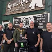 Coun Dale Grounds presents the portable defibrillator to landlord Richard Darrington and members of the Byron's Rest Walking Club. Photo: Submitted