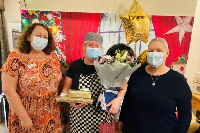 Singing cook Gillian Prowett receives flowers and gifts from Gaynor Smart-McCann and Lorraine Abbiss after being named employee of the year at Fairway View Care Home in Bulwell