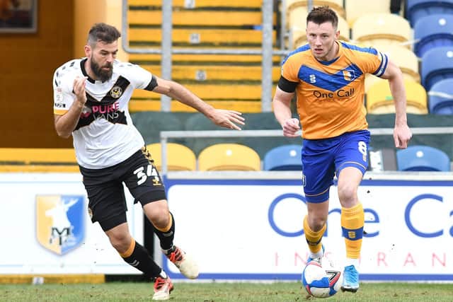 Mansfield's Ollie Clarke looks to find space away from Newport's Joe Ledley on Friday.
