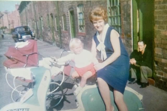 Alfred is seen sitting on the step in the background while his daughter Julie and grandson Russell are pictured on the motorbike