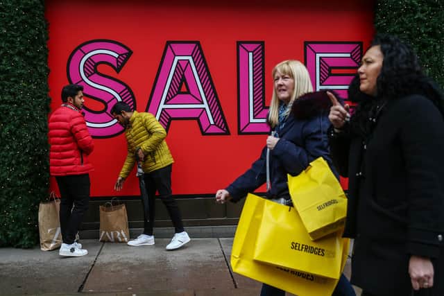 Shoppers carry bags during the Boxing Day sales. (Photo by Hollie Adams/Getty Images)