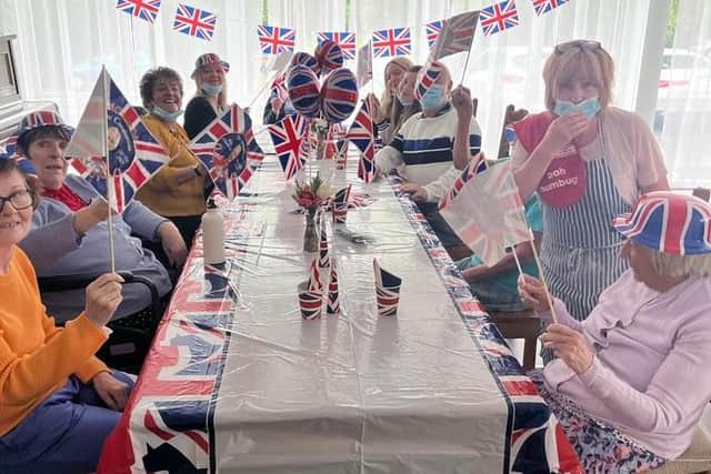 Park House Care Home radiates joy as they celebrate a birthday amid a vibrant Coronation Street/VE Day party.