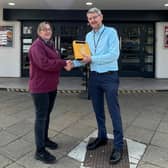 Kelly Golding receives the defibrillator for the Arc Cinema from Trevor Middleton, town centre and markets manager at Ashfield District Council