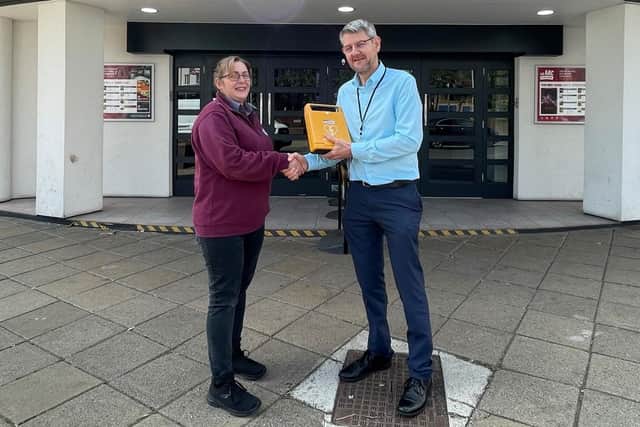 Kelly Golding receives the defibrillator for the Arc Cinema from Trevor Middleton, town centre and markets manager at Ashfield District Council