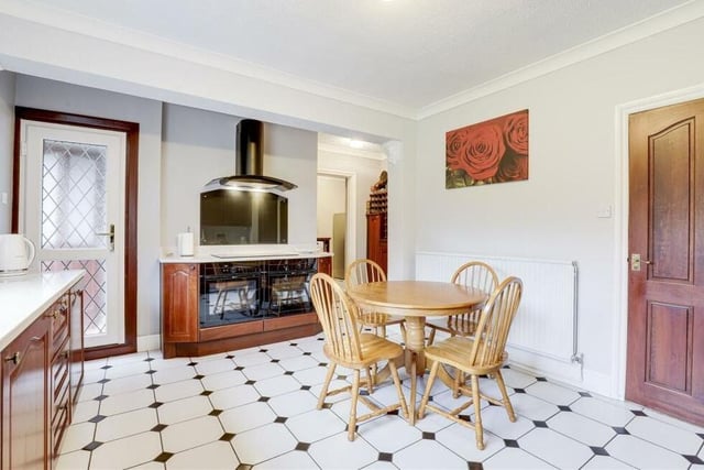 Integrated appliances in the kitchen include a double oven with an electric hob and extractor hood, a fridge and dishwasher. The floor is tiled, and the single uPVC door to the left provides access to a back porch.