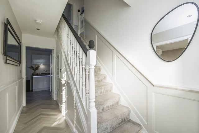 As we prepare to go upstairs, let's take a look at the entrance hall. It boasts Karndean flooring, wall panelling, spotlights to the ceiling and an under-stairs storage cupboard.
