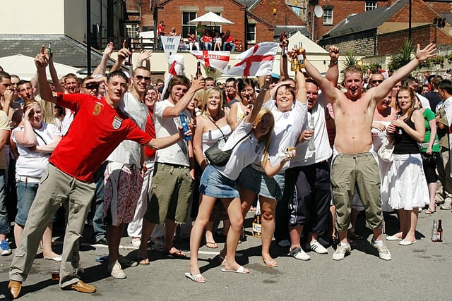 England fans celebrate in the sun. They were watching England's first 2006 world cup game on a huge screen in Mansfield's Swan Inn yard.