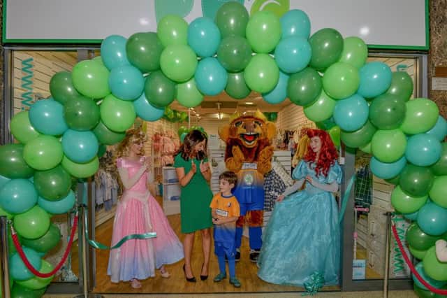 Opening of new childrenÃ¢Â¬"s clothing store Pud, owner Frances Bishop with Son Oscar cutting the ribbon watched by Disney princesses and Sammy The Stag