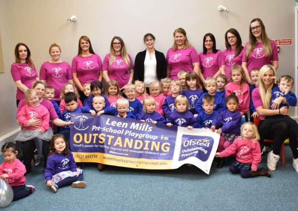 Manager Lesley Hopewell (back, centre) and staff celebrate their Outstanding Ofsted verdict with the playgroup children.