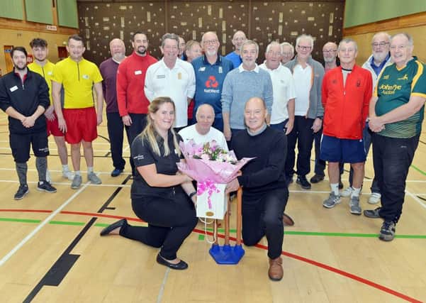 Merv Williams thanks staff and walking cricket teammates who saved his life at Hucknall Leisure Centre. He is pictured presenting flowers to operations manager Emma Smithurst. (PHOTO BY: Brian Eyre)