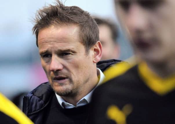 A grim faced Neal Ardley makes his way off the pitch.