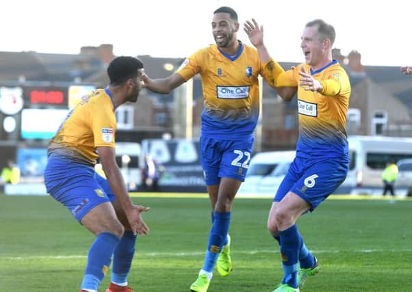 Mansfield's Neal Bishop celebrates his goal with his teammates Jacob Mellis (l) and CJ Hamilton at Grimsby.