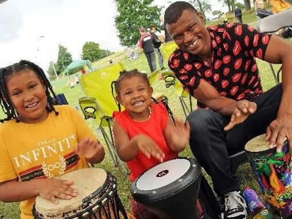 JD Bailey joins his daughters, Nylah Wray, 9 and Zayah Wray, 3, in the drumming tent.