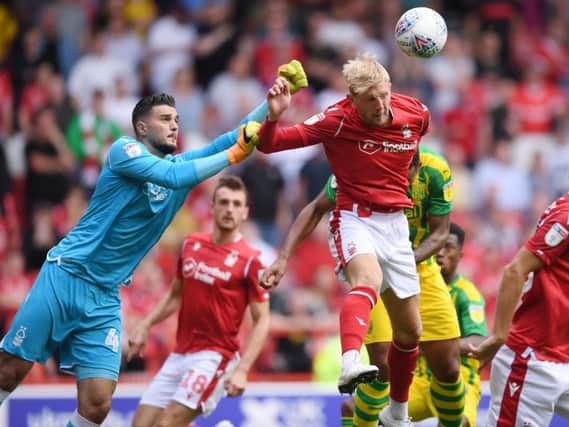 Joe Worrall heads clear as Aro Muric comes out for Forest against West Brom.