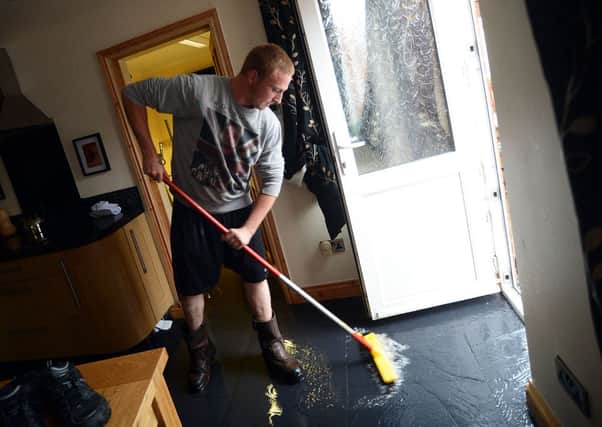 Hucknall flood.
De je vu! Craig Jones sweeps away flood water from mum, Wendy's home, a repeat picture after he was featured in the Dispatch aged around 4, doing the same thing.