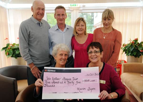 Marion Dyson presents £500 from a sky dive in memory of Kevin Smith to The John Eastwood Hospice. l-r back is Eric Dyson, Terry Connor, Julie Smith (Kevin's wife), and Tanya Yates. Front is Marion Dyson and Rosmary Pella.