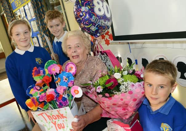 Mrs Margaret Hammond is presented with 80th birthday gifts from Lake View Primary School pupils, Ethan Warnes, Callum Cotterill and Caitlin Stendall as a thank you for her help at their Rainworth school, where she has worked as  classroom support for the last 13 years.