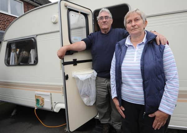 Ted and Elaine Mullane of Thoresby Dale have been living in their small caravan on their driveway as their house was completely flooded. Pictured with their caravan.