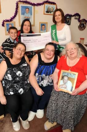 A family in Hucknall had a birthday party for Joshua 9 and raised money for Macmillan via a tombola raffle. back l-r is Joshua Hornby 9, Laura Hornby, Helena Monk Fundraising Manager for Macmillan. front l-r is Christine Hornby, Carol Hornby and Maureen Hornby holding a photograph of her late husband John who the party was in memory of.