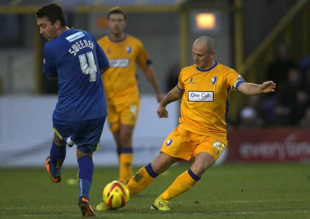 Wimbledon's Peter Sweeney takes evasive action as Mansfield captain Adam Murray hits a long ball out to the left wing during the first half