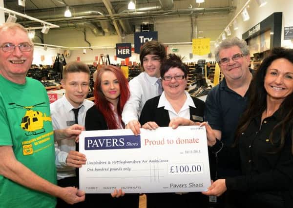 Store manager, Gail Day right, from the Pavers shop at the East Midlands Designer Outlet, hands over a £100 cheque to Dave Gibbon, left,  from the Lincs and Notts Air Ambulance, after the charity was chosen as the local recipients to celebrate the chain's 100 store opening.  Also pictured are staff, Jordan Whittaker, Asha Priestley, Jake Draycott, Jane Adlington and Robert Thompson.
