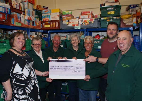 Hilary Cheshire, company secretary of Robert Woodhead (far left) presents a £500 cheque to Lyn Matthews (to her left).