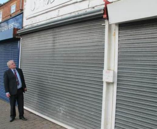Coun Jim Aspinall outside one of the empty shops that could be brought back into use through the grant funding scheme.