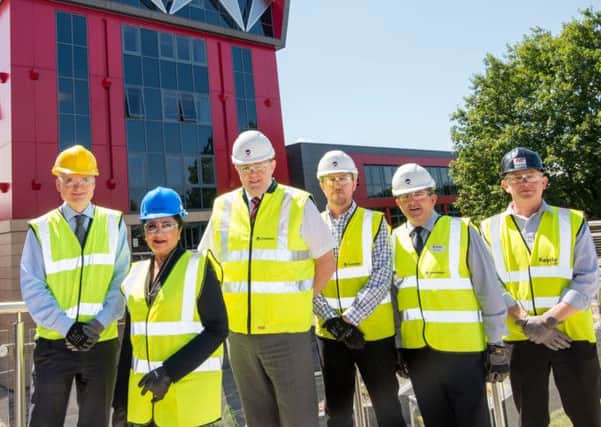 Pictured in front of the newly re-clad six-storey tower are (from left) Tom Stevens, the colleges executive director of capital projects and estates; Dame Asha Khemka, Martin Gallagher, Craig Smallman, Derek IAnson and Andy Lee.