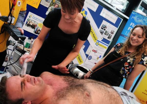 Mental Health nurse, Chris Majid, goes through the pain barrier for Kings Mill Hospital's Dementia Care Appeal after he agreed to have his body waxed by Claire Collier from the Kings Mill Hair and Beauty Salon last Friday, also pictured is his girlfriend Hannah Park.