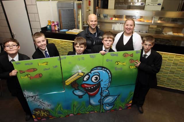 Kirkby students have designed a piece of artwork with help from artist Phil Riley and presented it to Stella Kyriacou from Kingsway Fishbar in Kirkby.