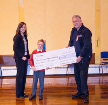 Toby Gartlend aged 7 hands over a cheque for £135 to the British Limbless Ex-servicemen Association. L-R: Ms Julie Jenkins (headteacher), Toby, Charley Streather.