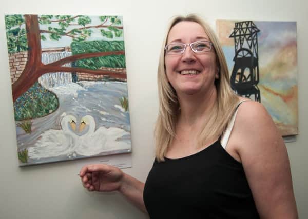 Parent Dawn Tomlinson displays her work a collaboration between Samworth Church Academy students and their parents in an art exhibition at Mansfield library inspired by the local Mansfield landscape.