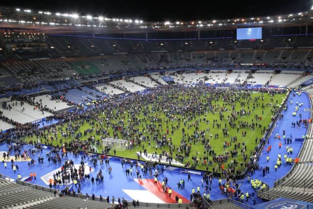 Spectators invade the pitch of the Stade de France stadium after the international friendly soccer France against Germany, Friday, Nov. 13, 2015 in Saint Denis, outside Paris. At least 35 people were killed in shootings and explosions around Paris, many of them in a popular theater where patrons were taken hostage, police and medical officials said Friday. Two explosions were heard outside the Stade de France stadium.