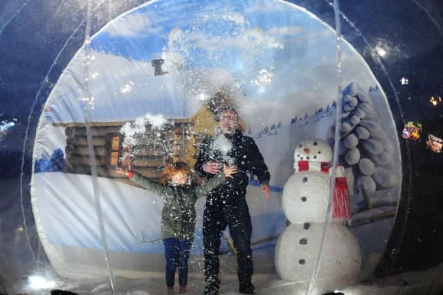 Kirkby Christmas lights.   
Ashley and Chloe Savage from Kirkby get the snow flying in a giant snowdome.