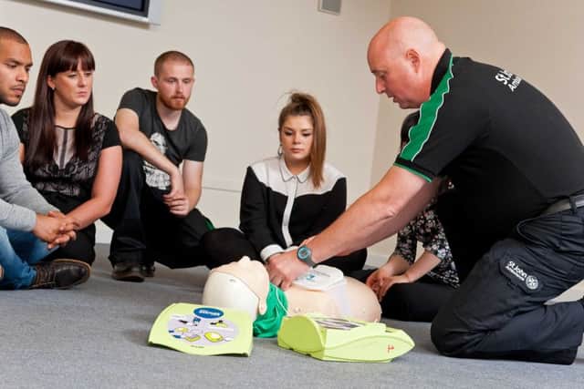 First aider giving defibrilator instruction.