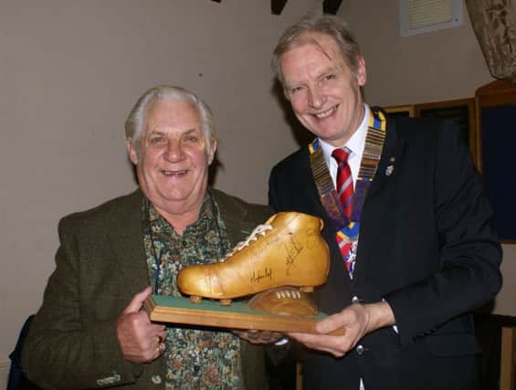 Jack Darrington is pictured showing the carved football boat to President Kevin Rostance